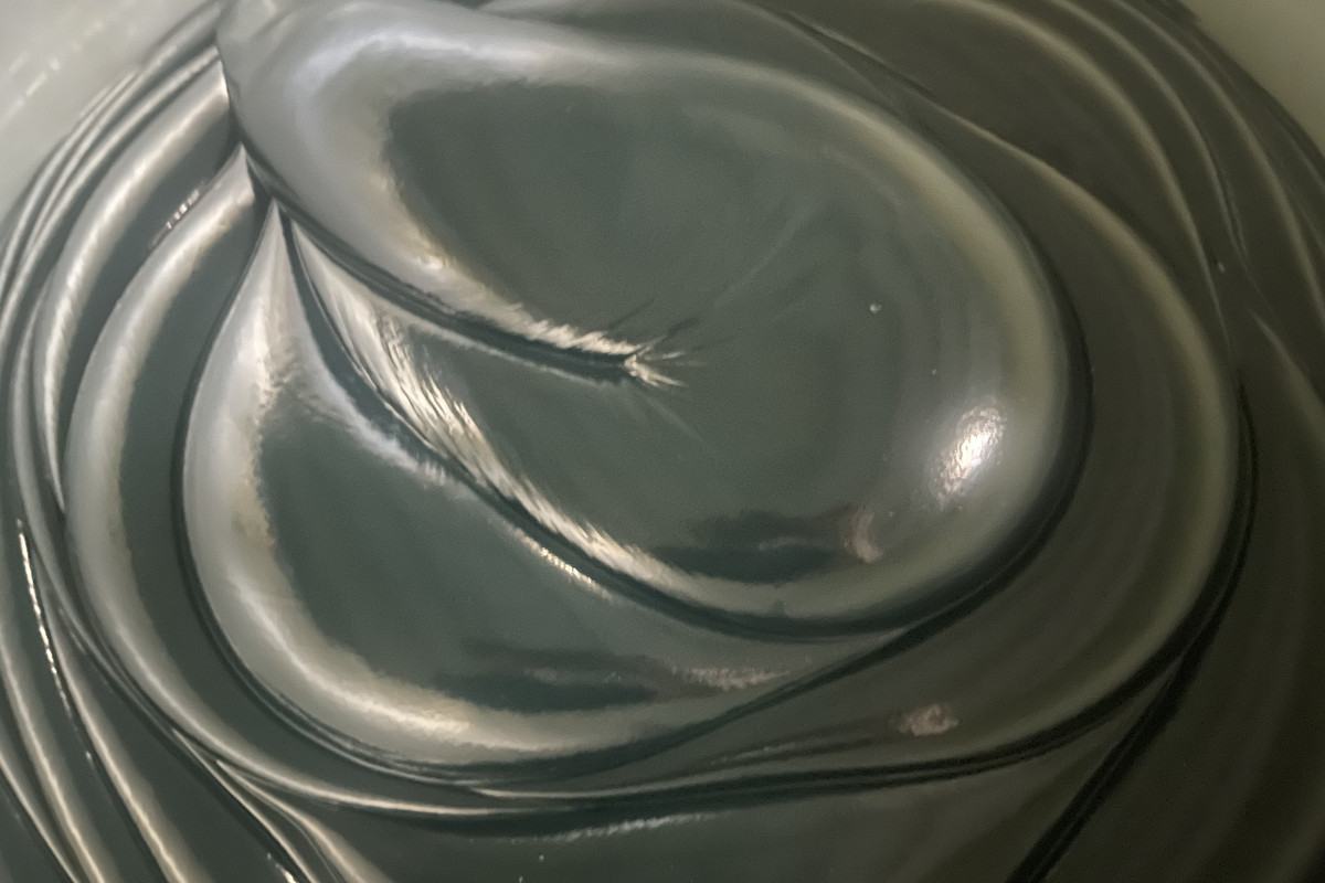 Smooth dark gray anhydrous calcium grease with satin finish in open pail